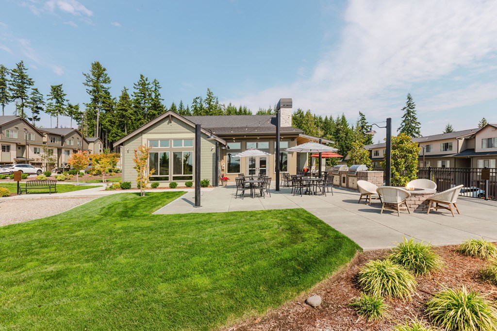 A sunny day at a park with a gazebo and picnic tables.