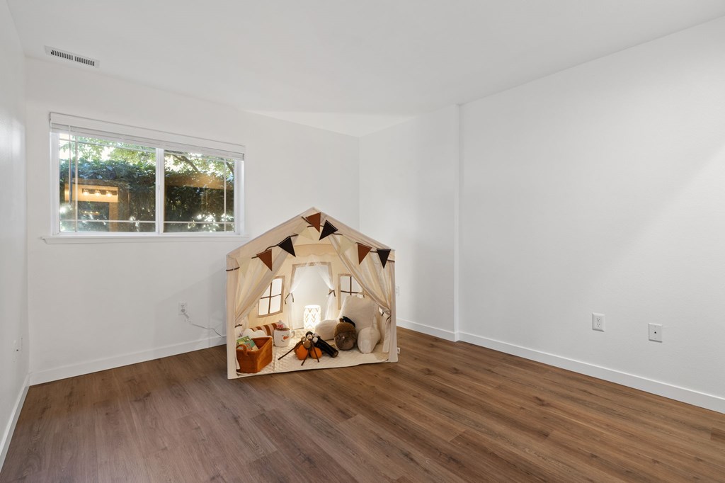 A dollhouse is sitting in a white room.