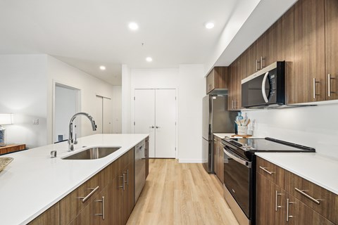 A modern kitchen with wooden cabinets and stainless steel appliances.