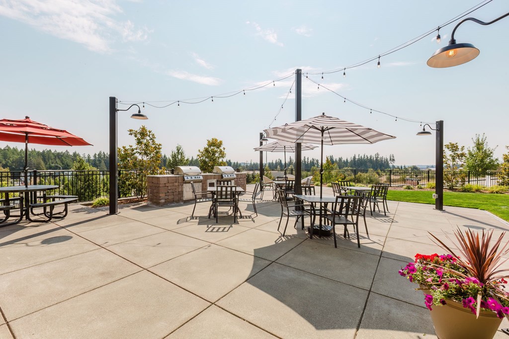 A patio with tables and chairs under umbrellas.
