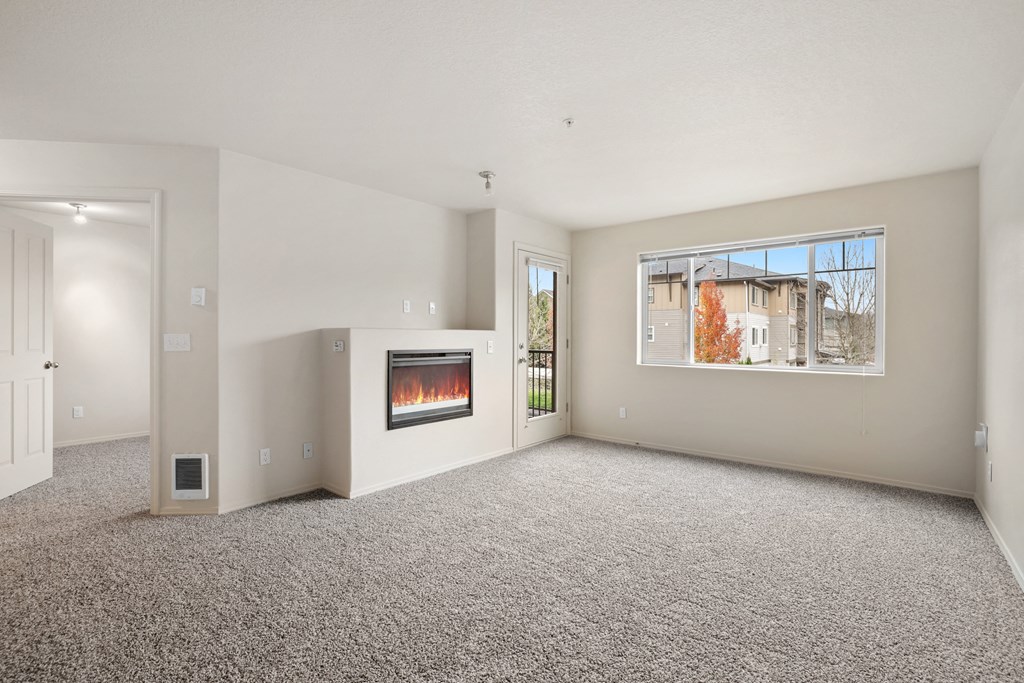 an empty living room with a fireplace and a window