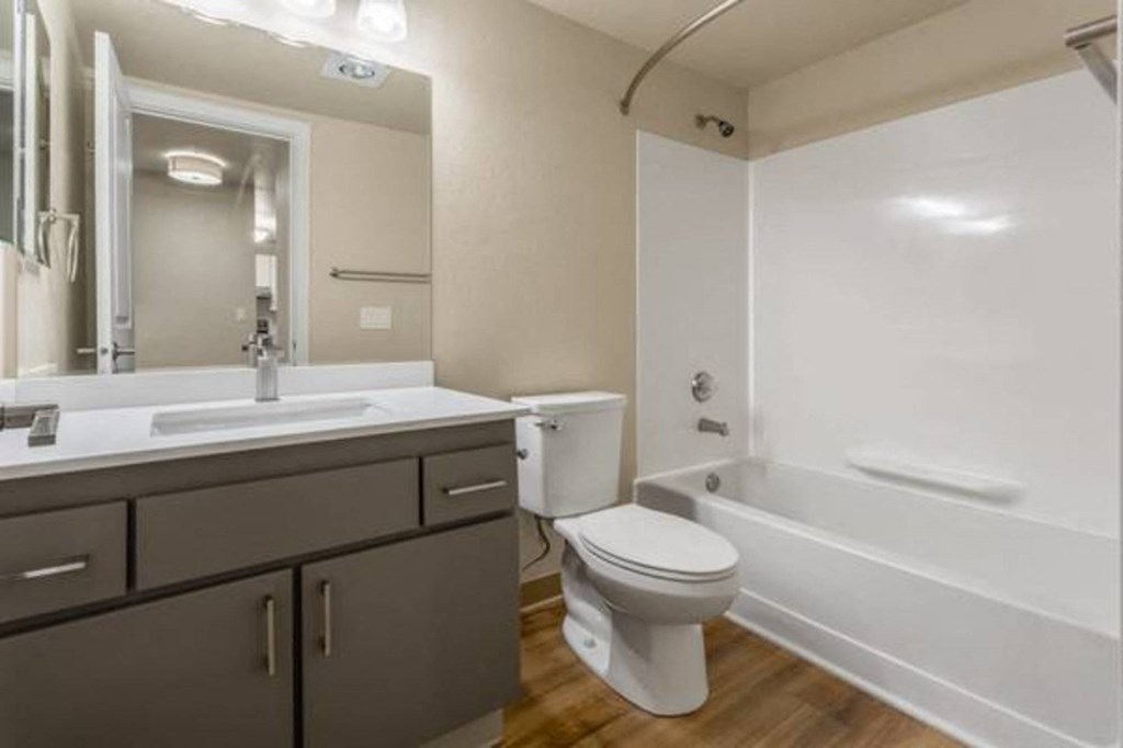 A bathroom with a white tub, sink, and toilet.