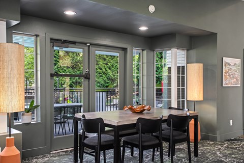 A dining room with a table and chairs.