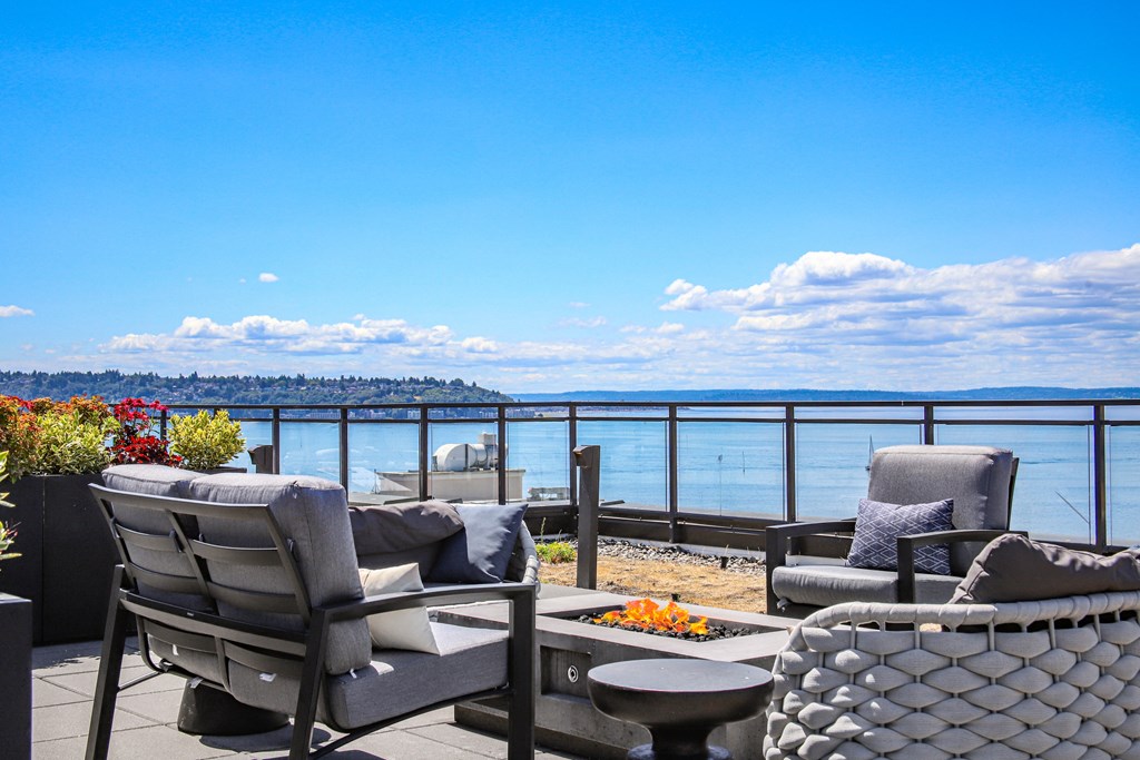 a patio with chairs and a table overlooking the ocean