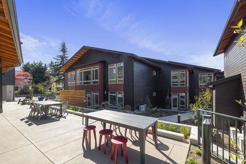 A patio with a table and chairs is in front of a building.