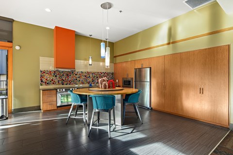 A kitchen with a table and chairs.