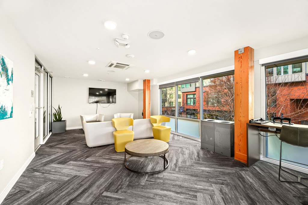 A modern office space with a grey carpet and a wooden pillar.