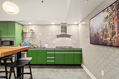 A kitchen with green cabinets and a wooden table.