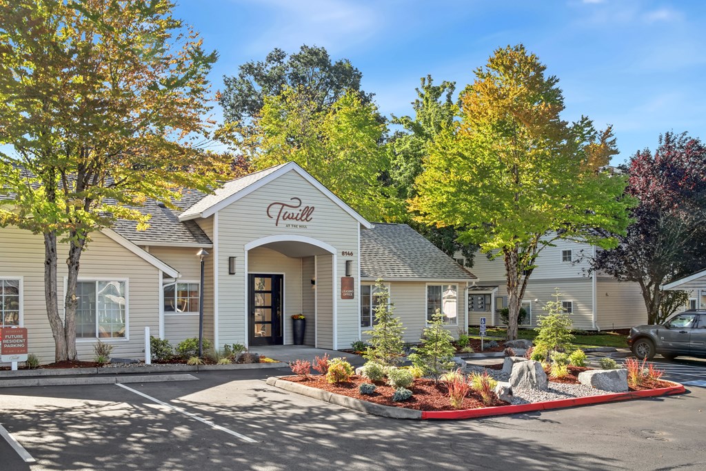 A white building with the word "Fairfield" on it is surrounded by trees and plants.