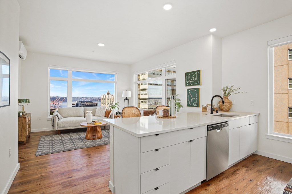 A kitchen with white cabinets and a large island.