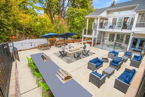 A patio with a table and chairs is surrounded by trees.