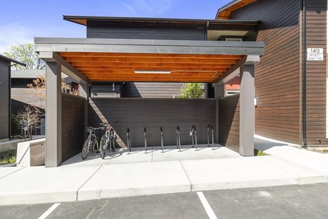 A modern building with a bicycle and a bench in front of it.