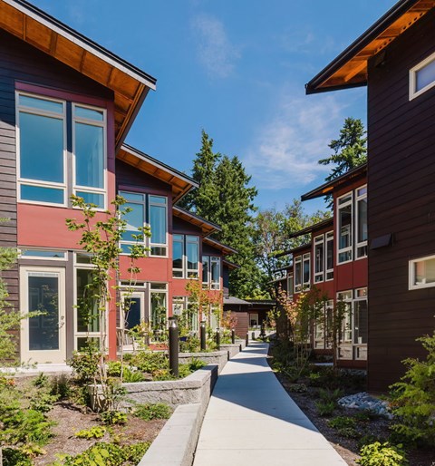 A long white walkway leads between two rows of modern houses.