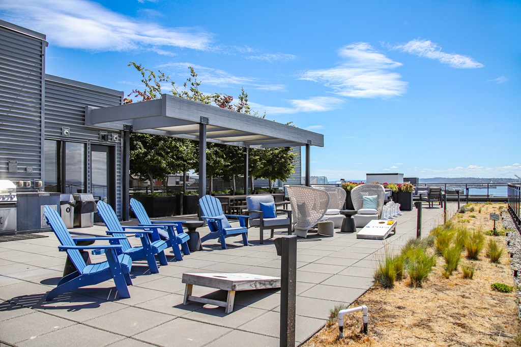 a patio with blue chairs and tables and a roof terrace