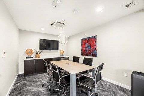 A conference room with a long table and chairs.