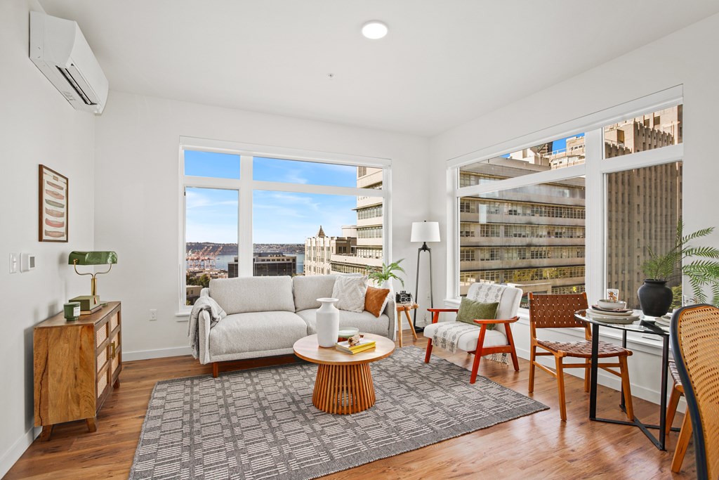 A living room with a white couch and a large window.