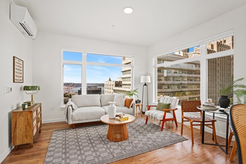 A living room with a white couch and a large window.