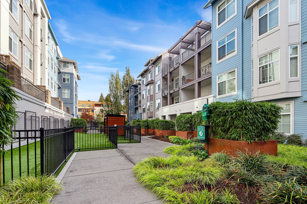 A pathway leads to a gated entrance in a residential area.