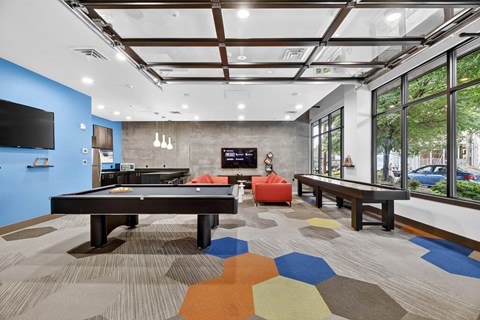 A room with a pool table and a TV.