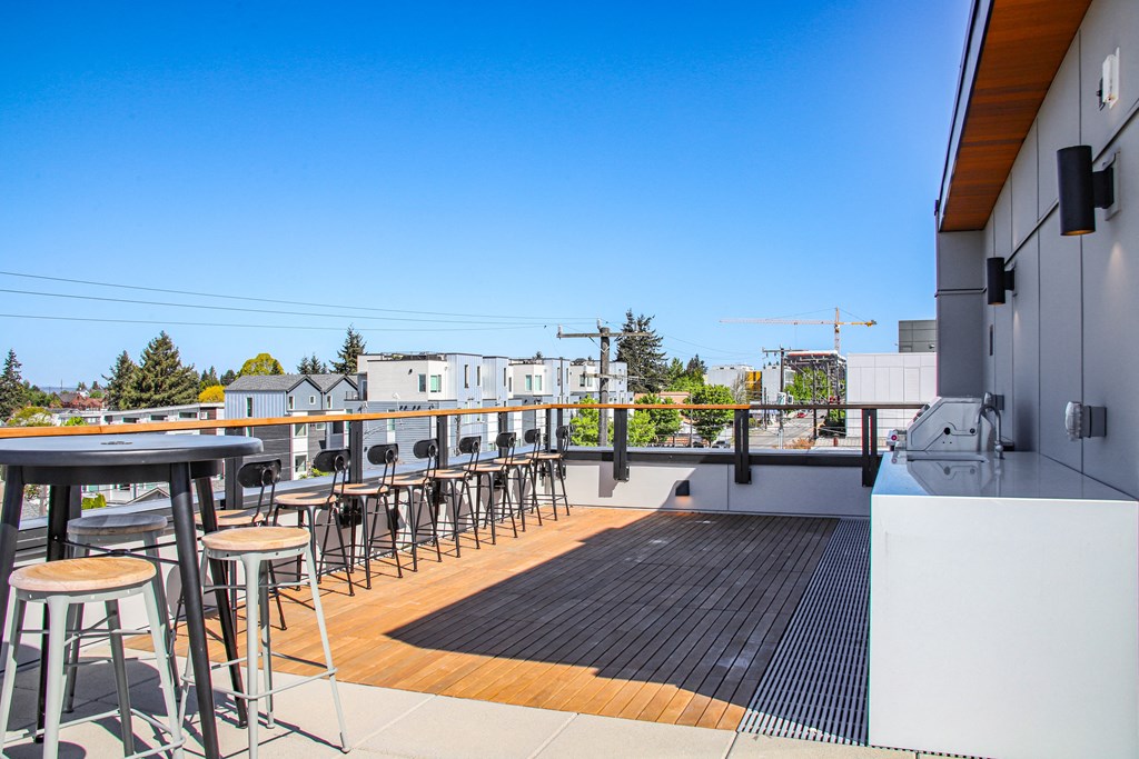 the deck of the bar area of a restaurant with tables and stools on it
