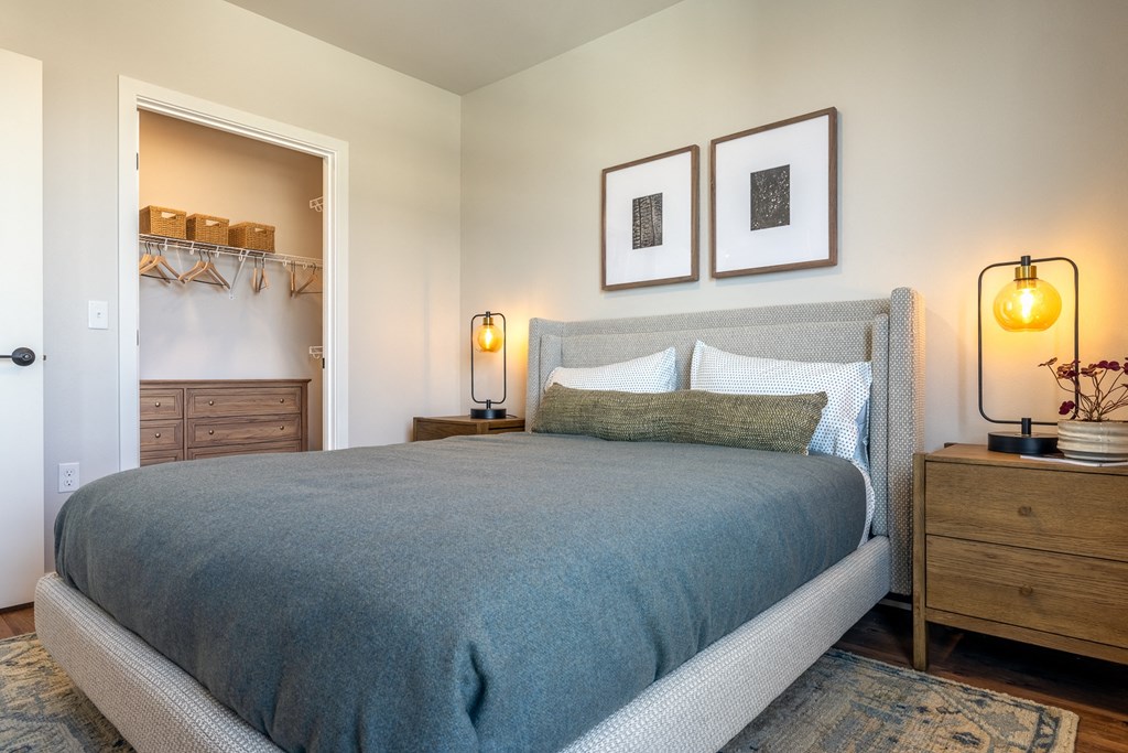 A bedroom with a bed, nightstands, and a lamp.