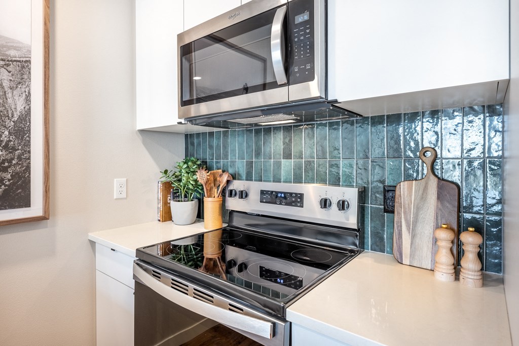 A modern kitchen with a stove top oven and microwave above it.