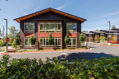 A modern building with a red roof and a sign that says "No Entry" in front of it.