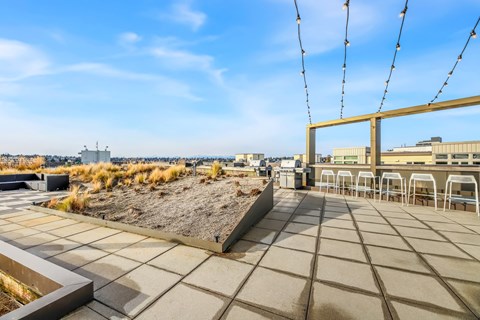 A rooftop patio with a view of the cityscape.