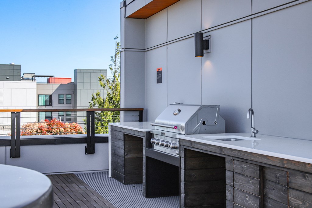 a kitchen with a grill and a sink on a balcony