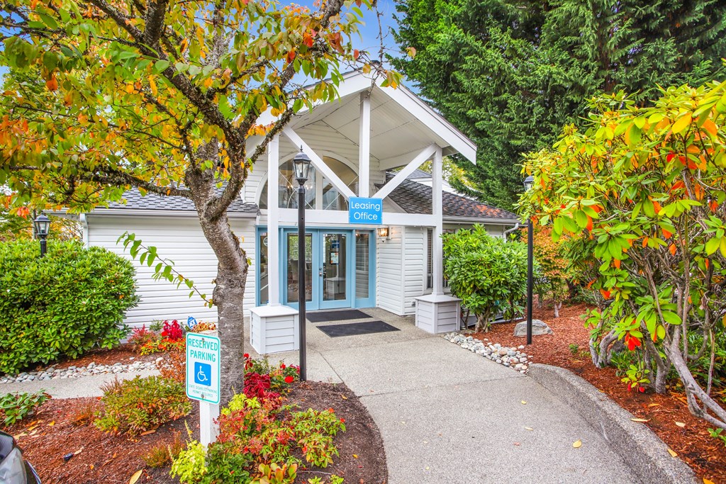 A small white building with a blue sign in front of it.