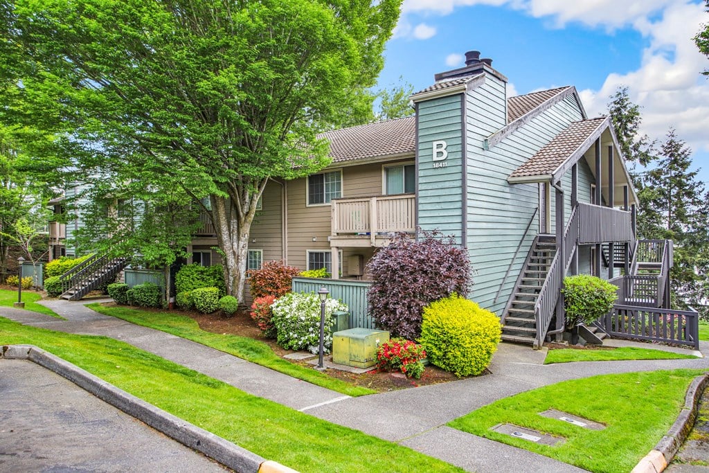 a house with a yard and a sidewalk in front of it