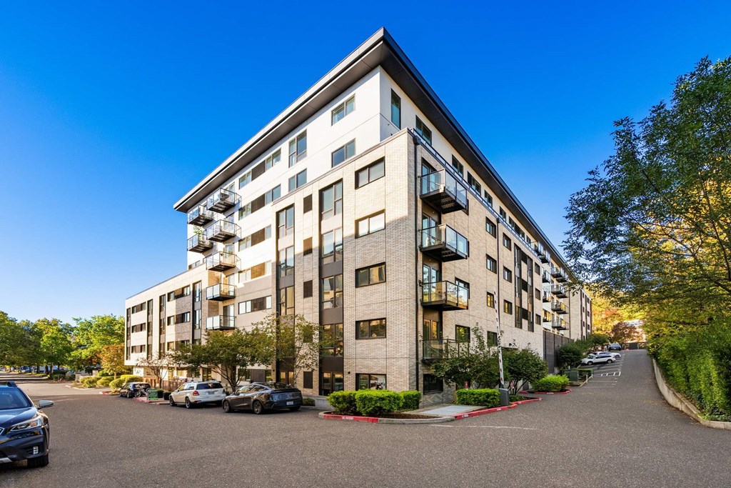 A large apartment building with a parking lot in front.