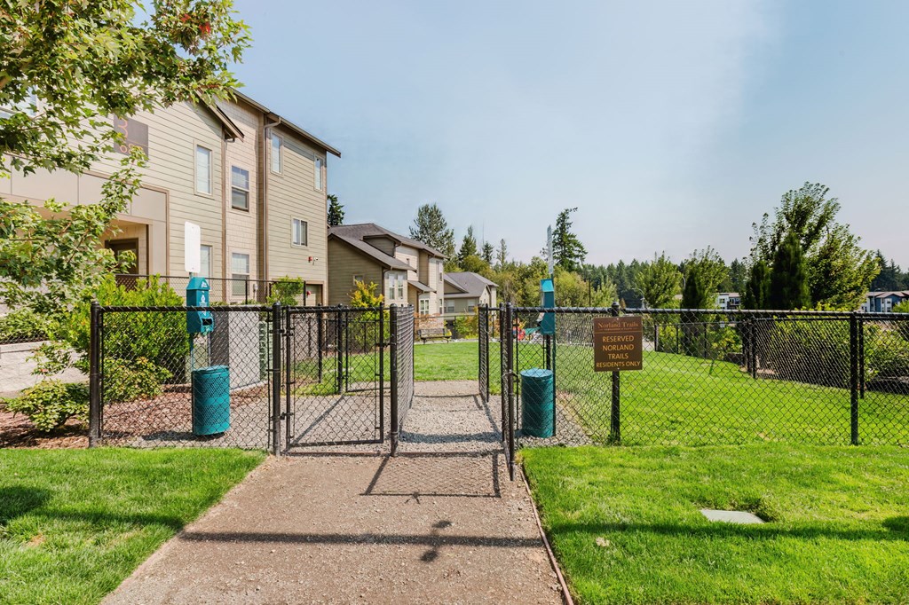 A gated entrance to a residential area with a signboard.