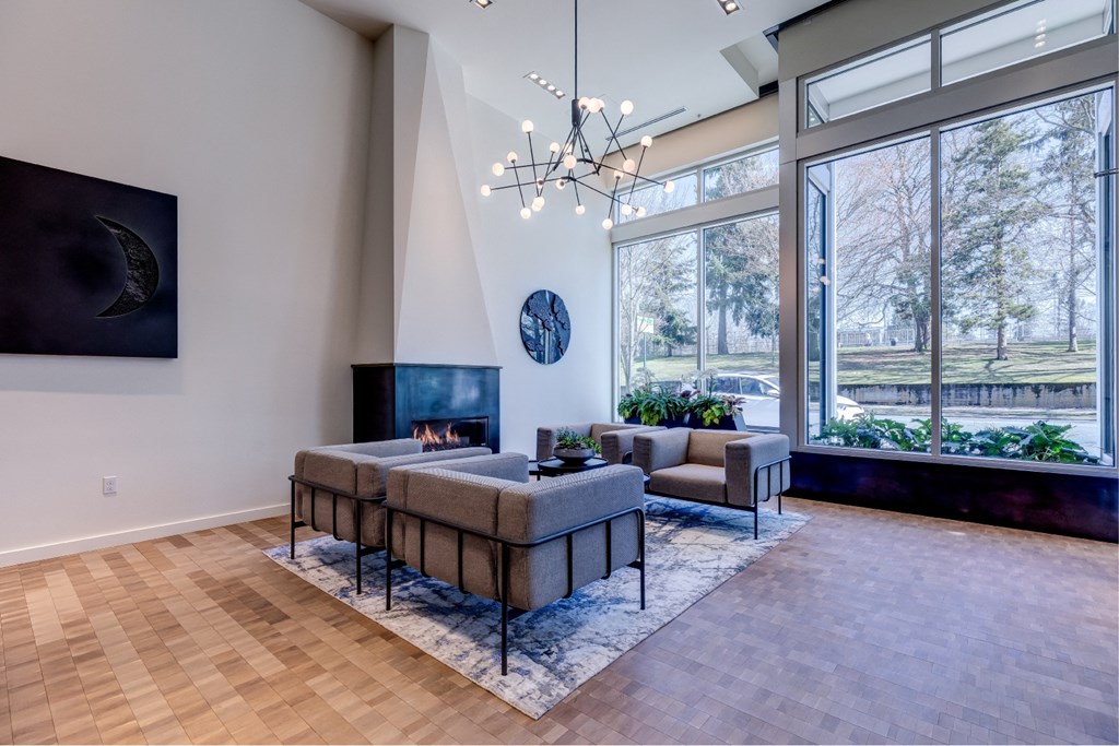 A modern living room with a fireplace and a large window.