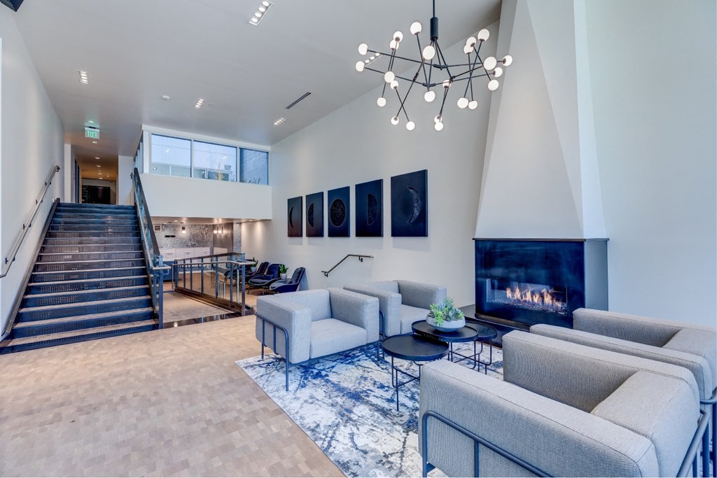 A modern living room with a fireplace and a staircase.