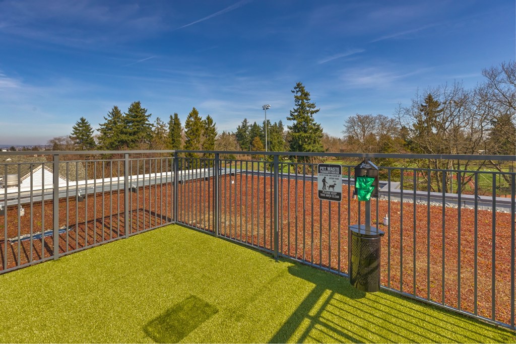 A tennis court surrounded by a fence with a sign on it.