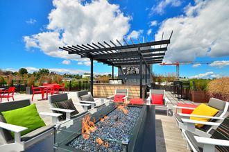 the patio on the top of the building features a fire pit and outdoor seating