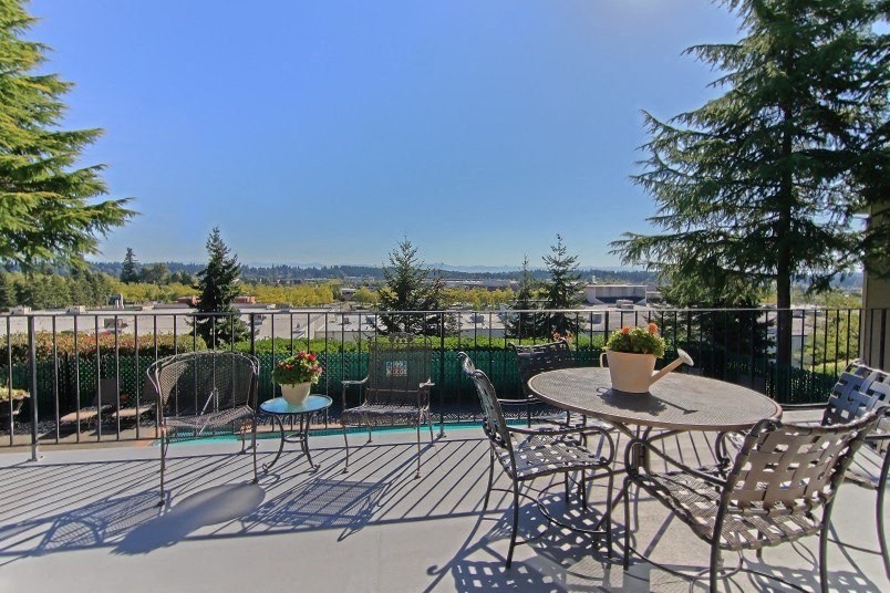 a patio with chairs and tables and a pool