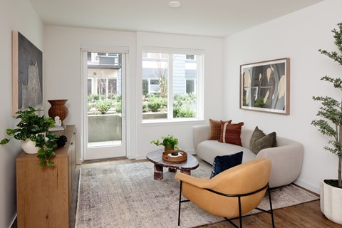 A living room with a yellow chair and a brown table.
