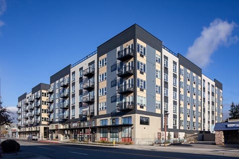 A large, modern apartment building with balconies on the upper floors.
