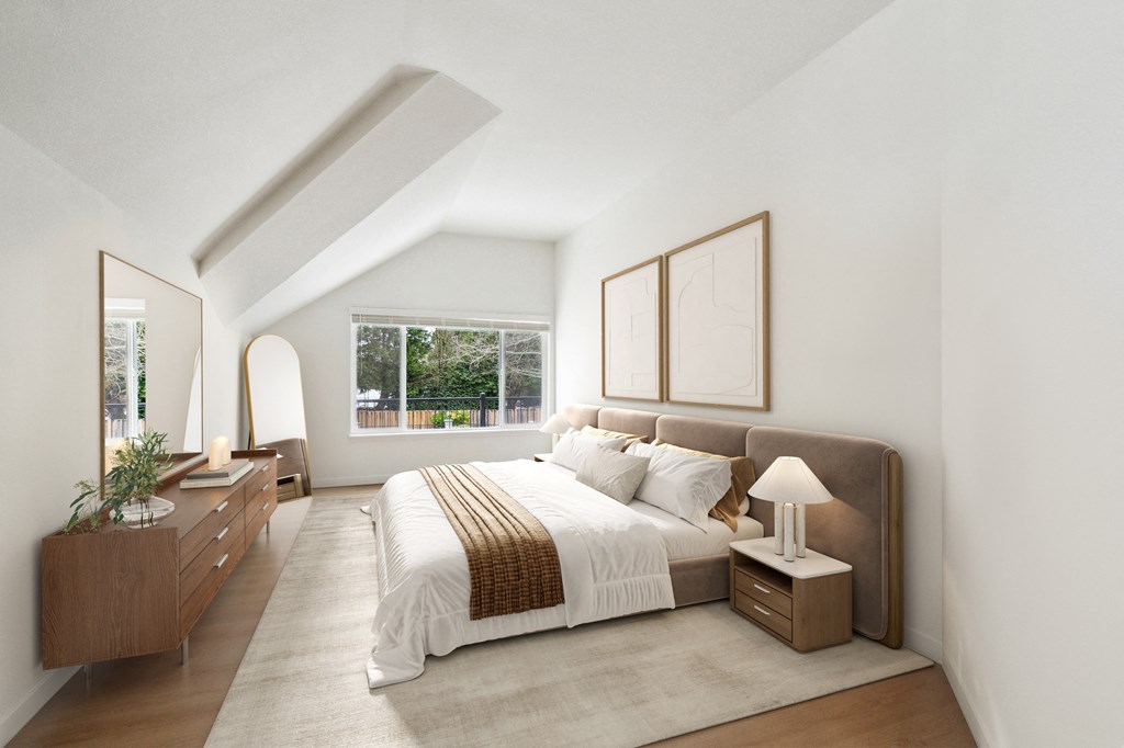 A bedroom with a large bed, nightstands, and a window overlooking a tree-filled yard.