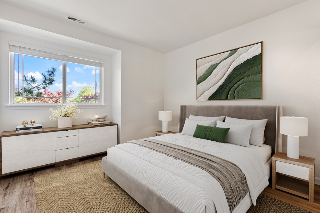 A bedroom with a large bed, a nightstand with a lamp, and a painting on the wall.