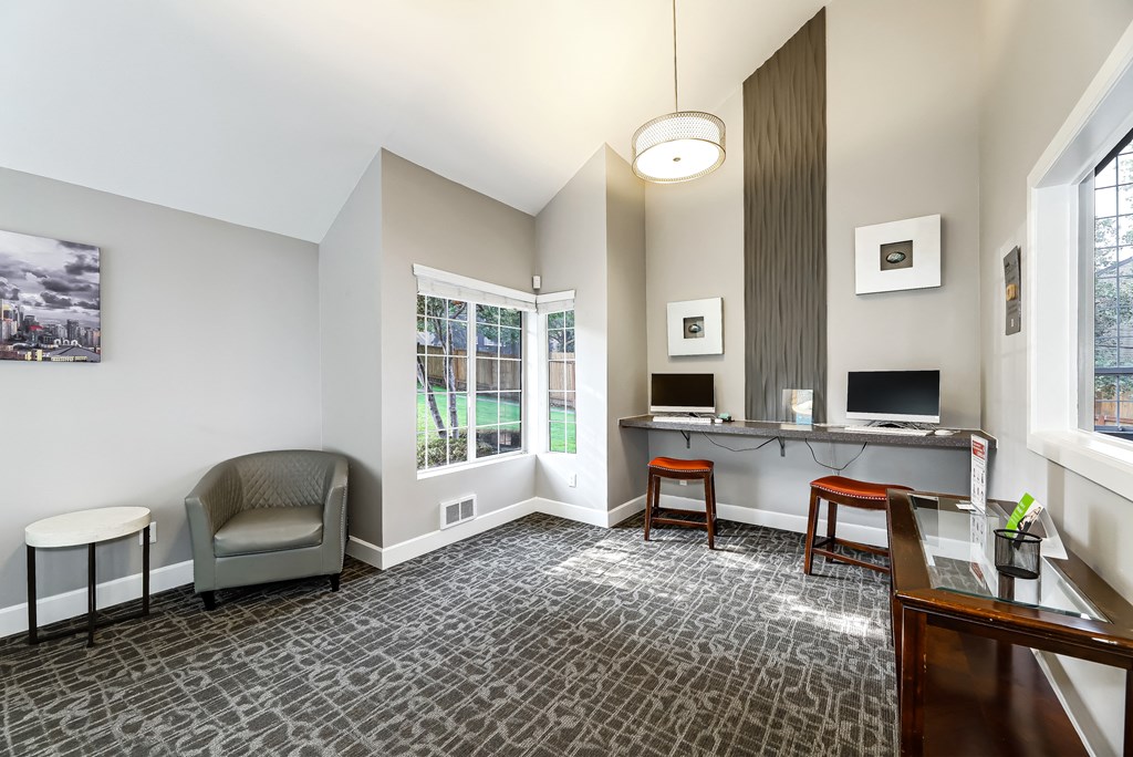 a living room with a desk and a chair and a window