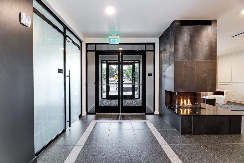 a lobby with a fireplace and glass doors