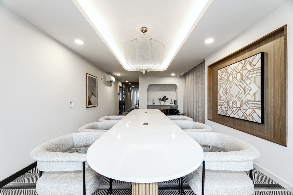 a long white meeting room with chairs and a table