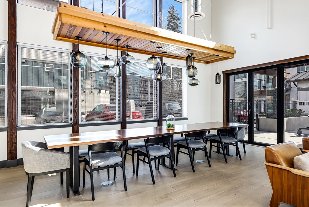 a dining room with a long table and chairs and a large window