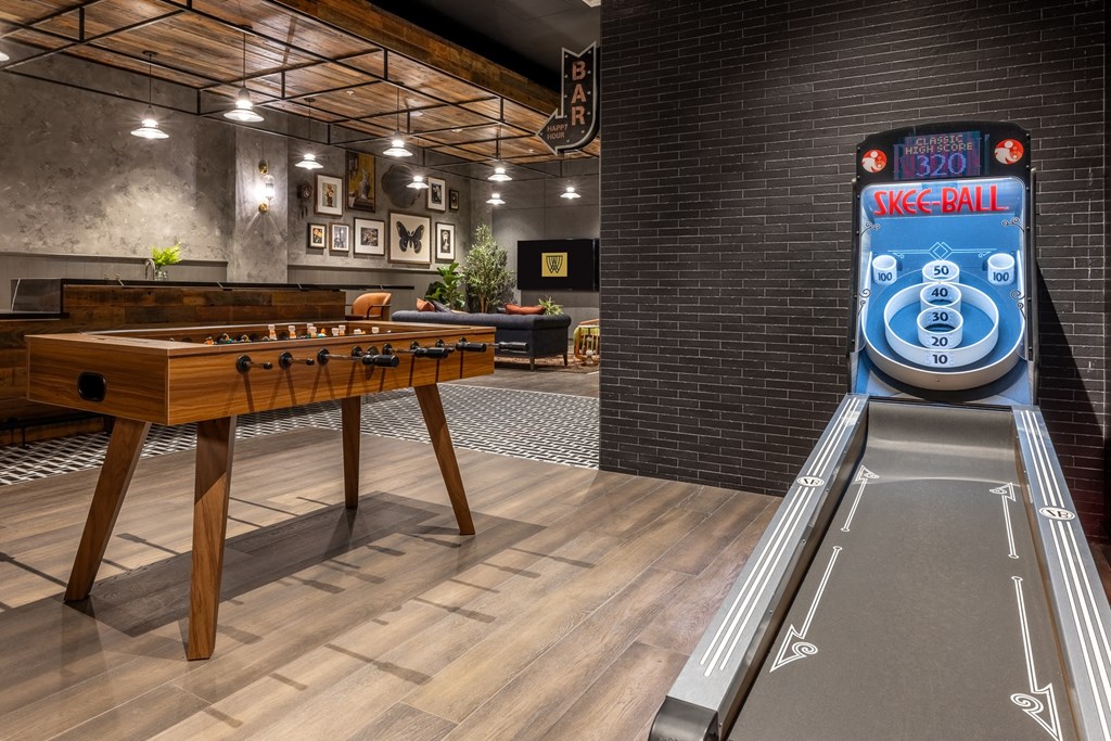 a foosball table in a room with a bowling ball machine