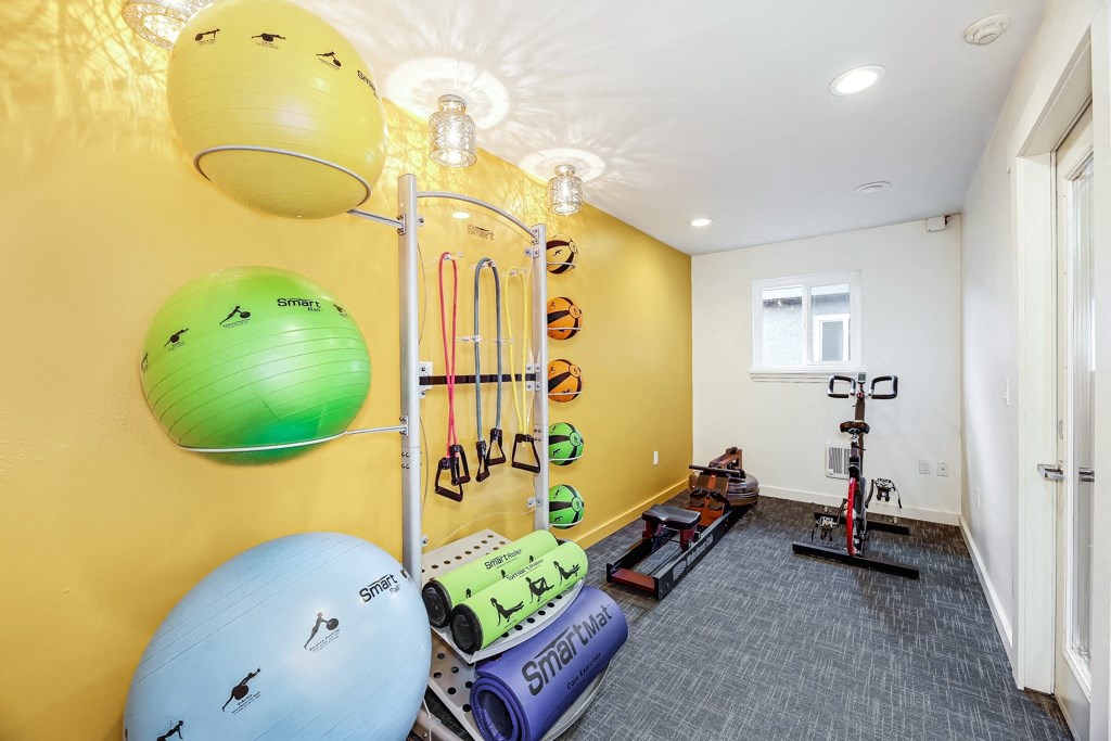 a home gym with weights and equipment and a yellow wall