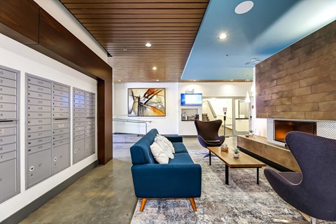 A modern living room with a blue couch and a fireplace.