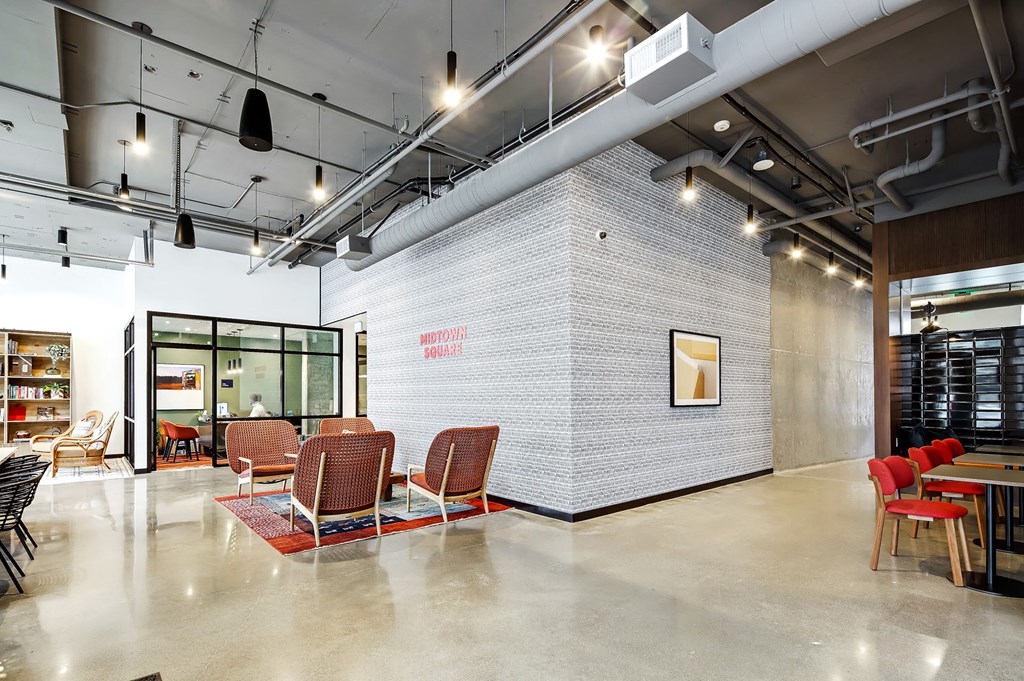 a room with chairs and tables and a brick wall